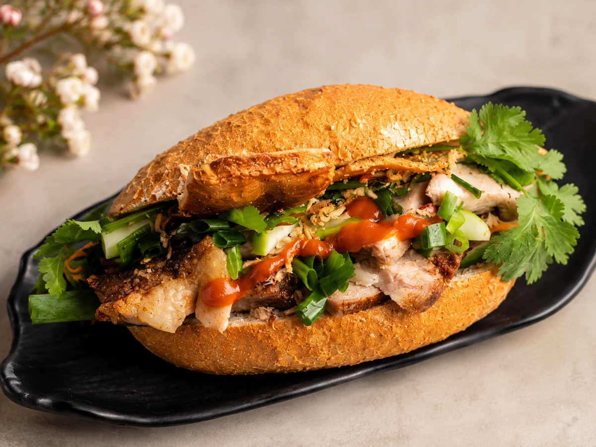 A Great Aunty Three roast pork and crackle banh mi on a Vietnamese baguette with fresh coriander and chilli